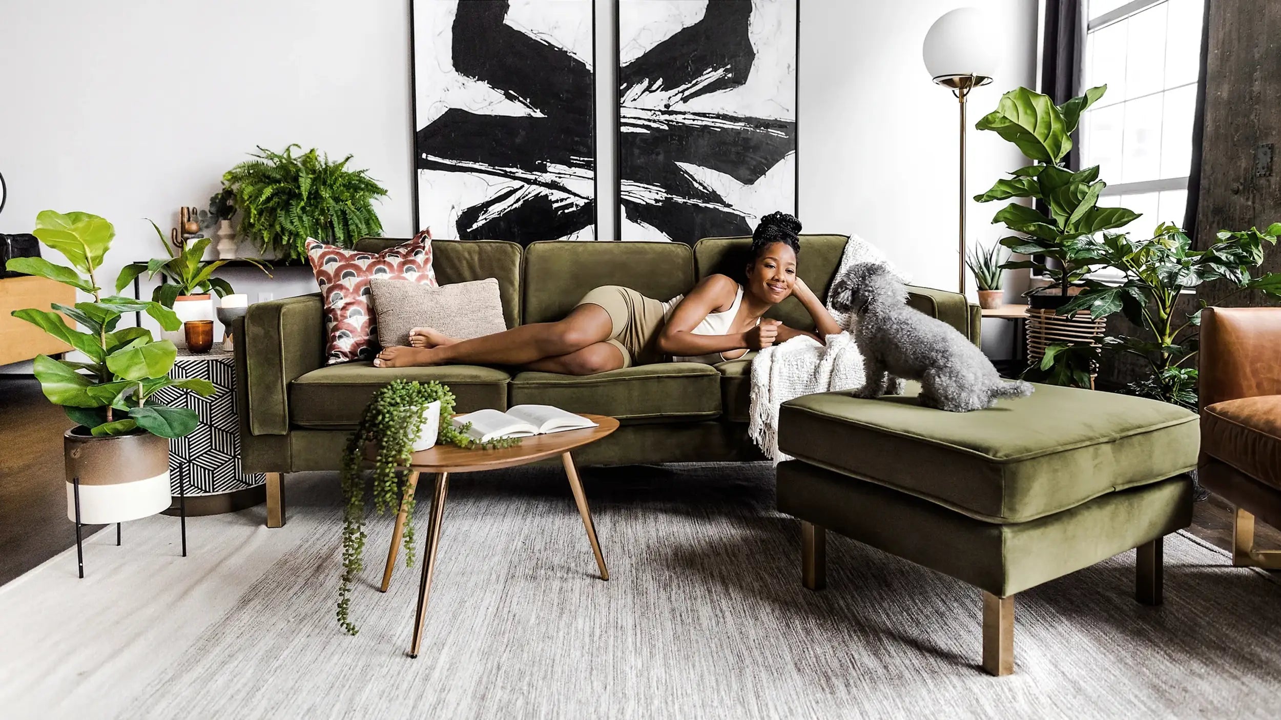 Woman laying down on the Albany Sofa in Olive Velvet