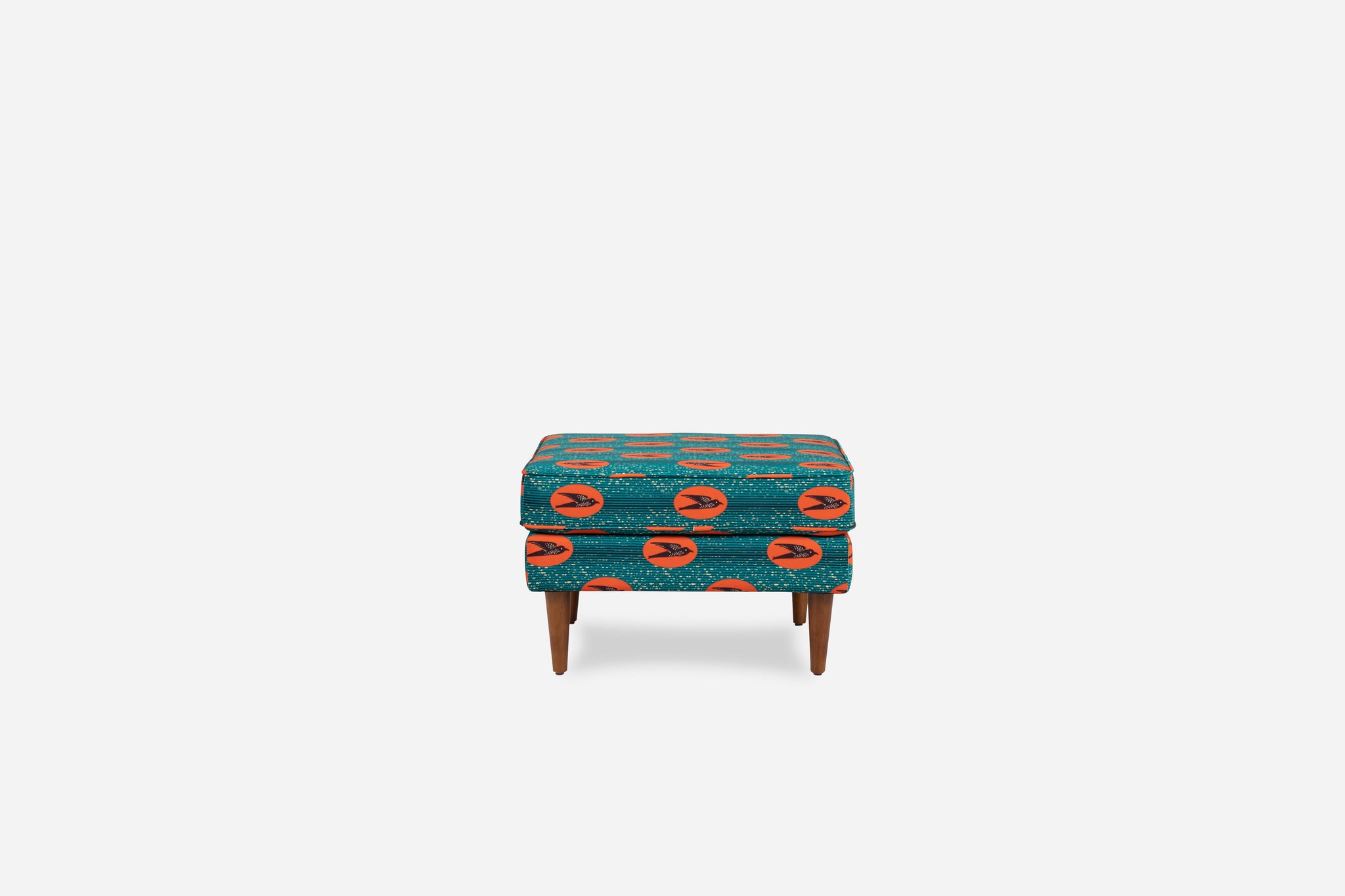 ẹkáàbọ̀ albany ottoman shown in akwaaba velvet with walnut legs