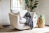 white bouclé | Park swivel armchair in boucle fabric with a grey throw
