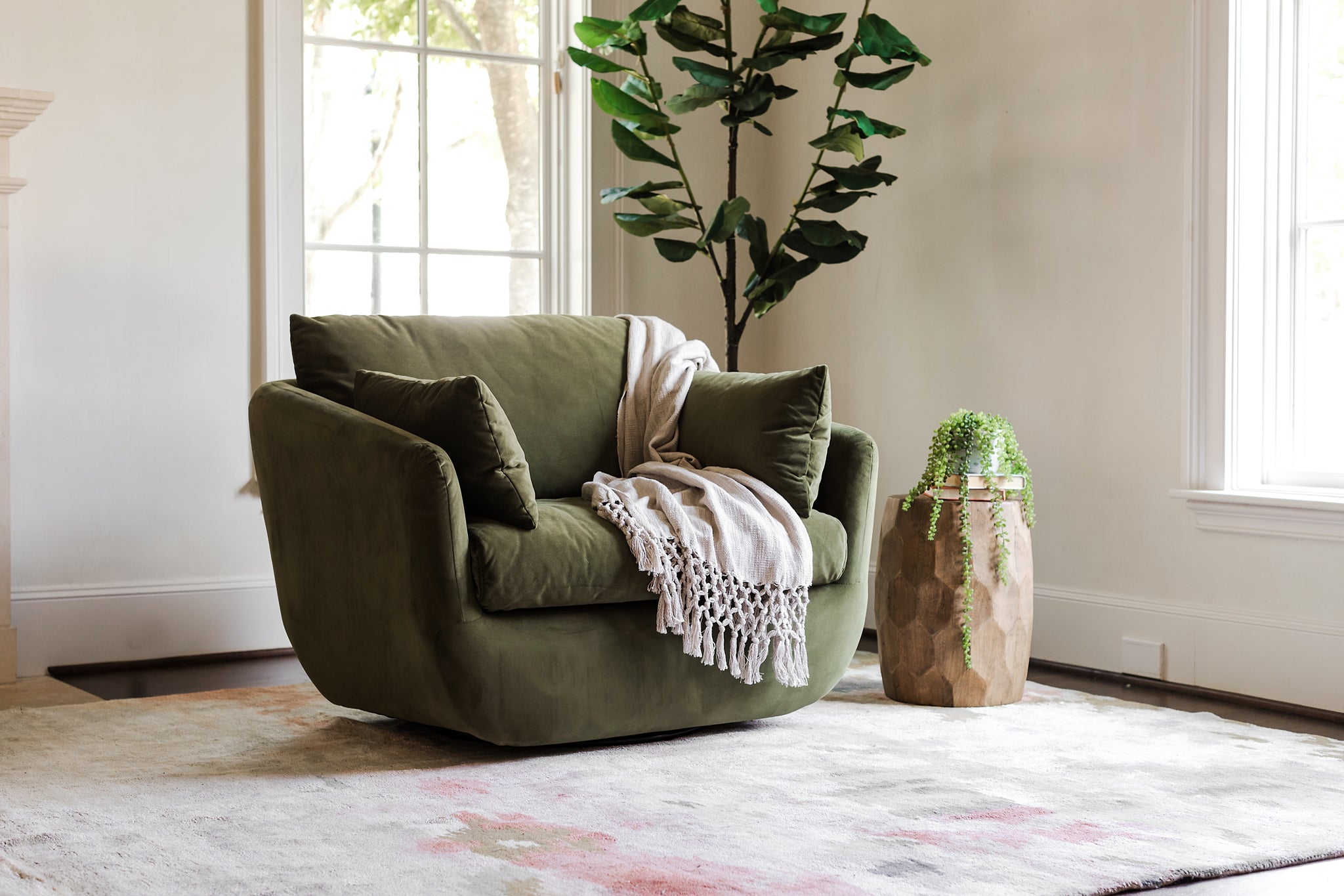 park swivel armchair in olive velvet with a white throw