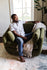 Olive Velvet | Man seated in the Park swivel armchair in olive velvet