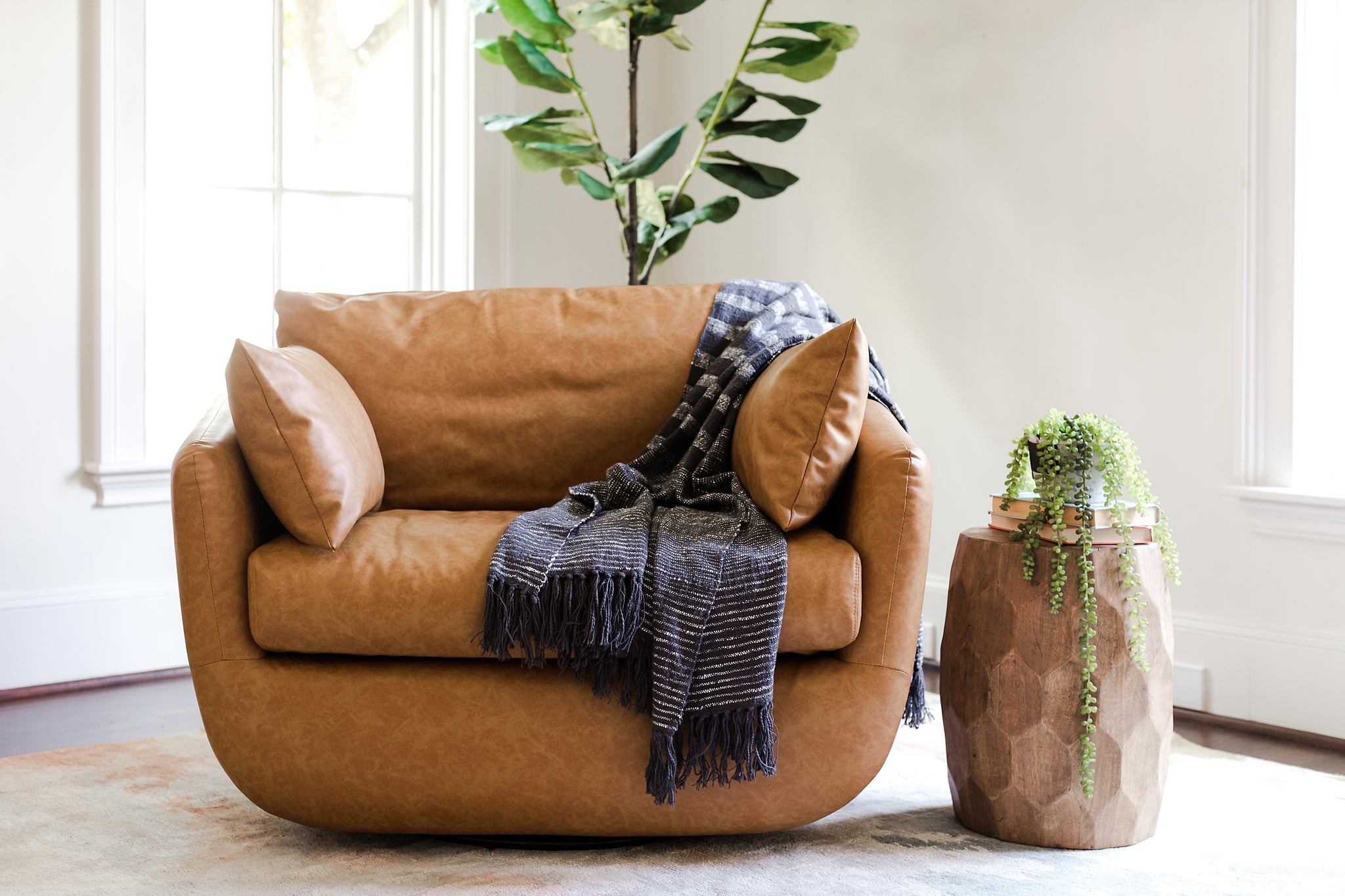 front of the park swivel armchair in distressed vegan leather in a living room setting