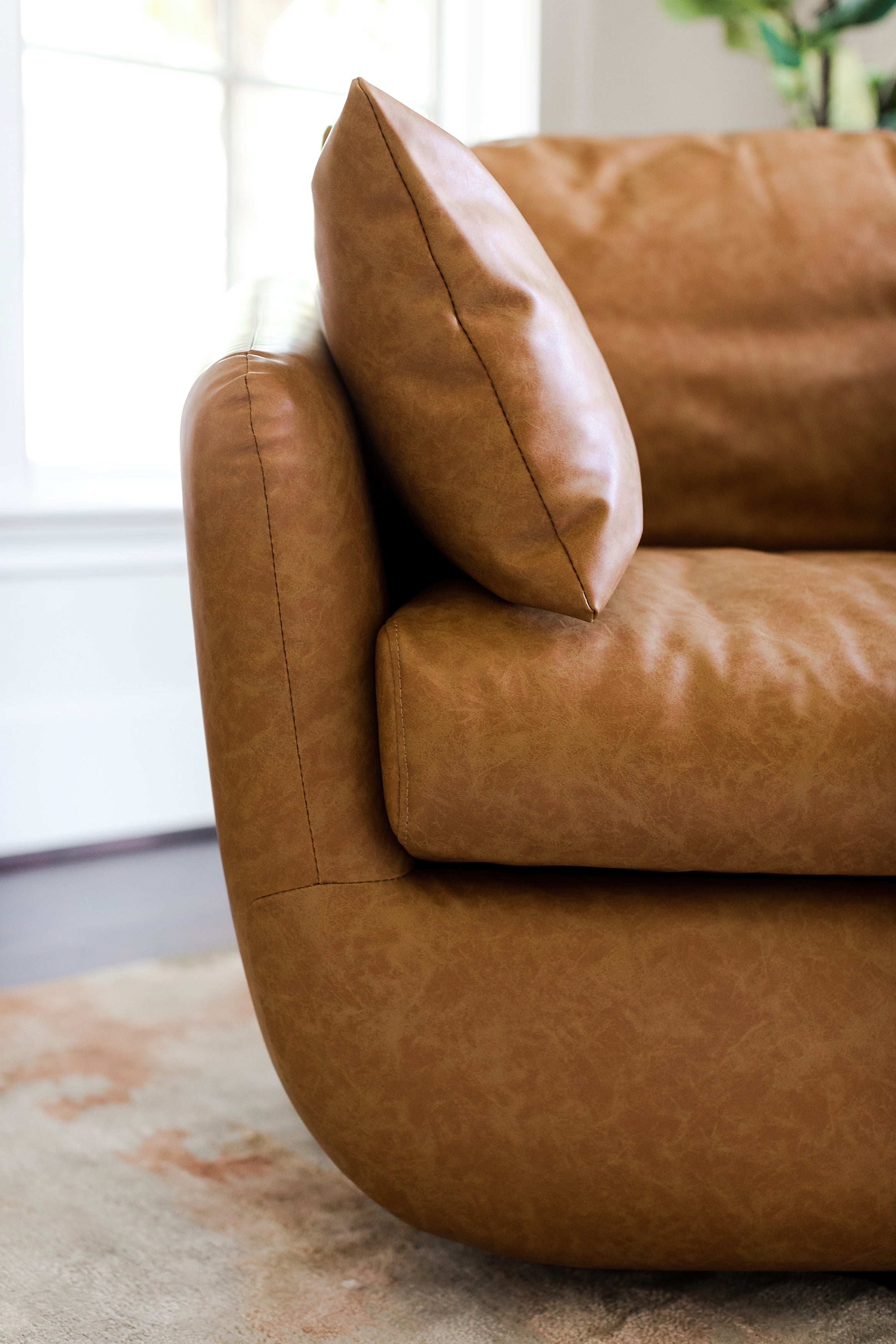 distressed vegan leather | detail of the armrest of the park swivel armchair in distressed vegan leather