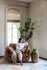 distressed vegan leather | woman seated in park swivel armchair in distressed vegan leather in a living room setting