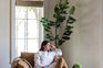 distressed vegan leather | woman seated in park swivel armchair in distressed vegan leather in a living room setting