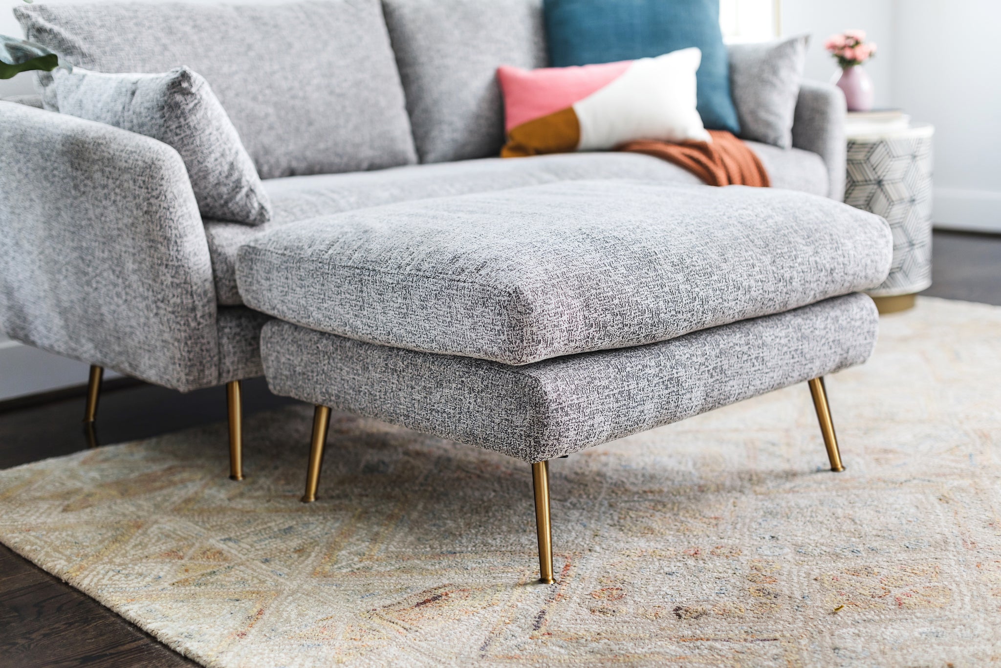 park ottoman shown in grey fabric with gold legs