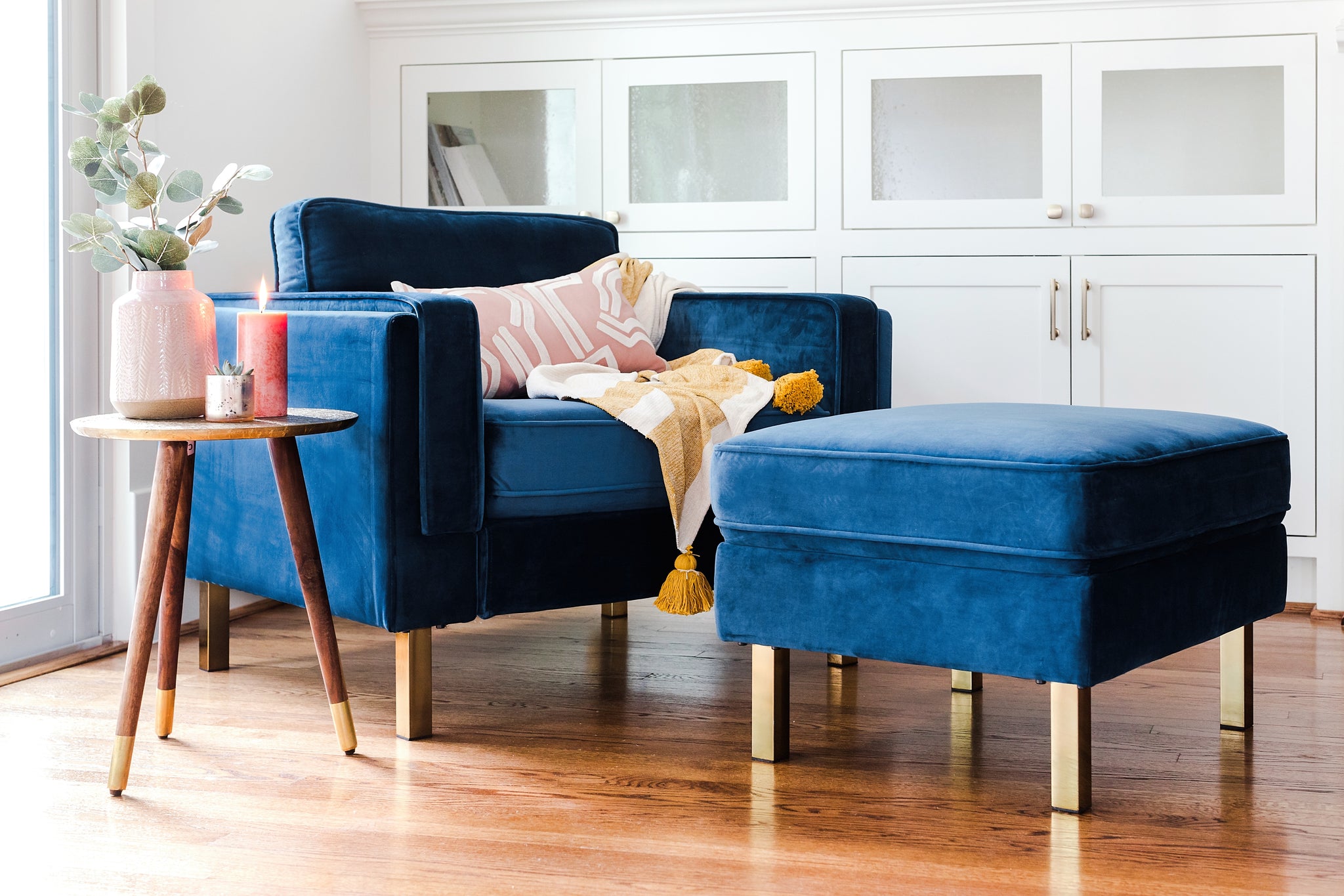 albany ottoman shown in blue velvet with gold legs