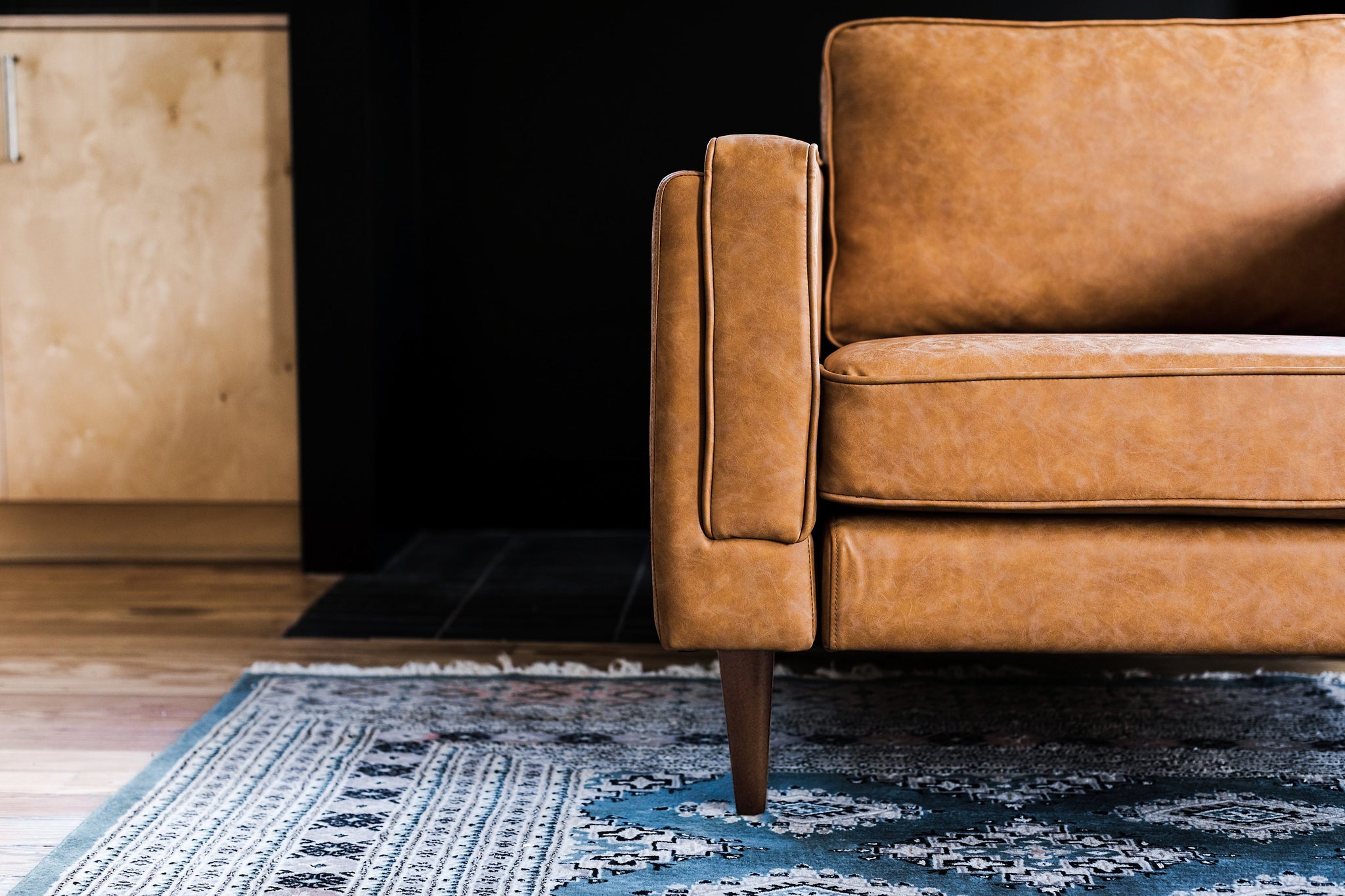 albany armchair shown in distressed vegan leather with walnut legs