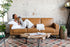 distressed vegan leather gold | Woman seated with her dog in the Albany sleeper sofa in vegan leather