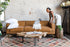distressed vegan leather gold | Woman opening the Albany sleeper sofa in vegan leather with gold legs