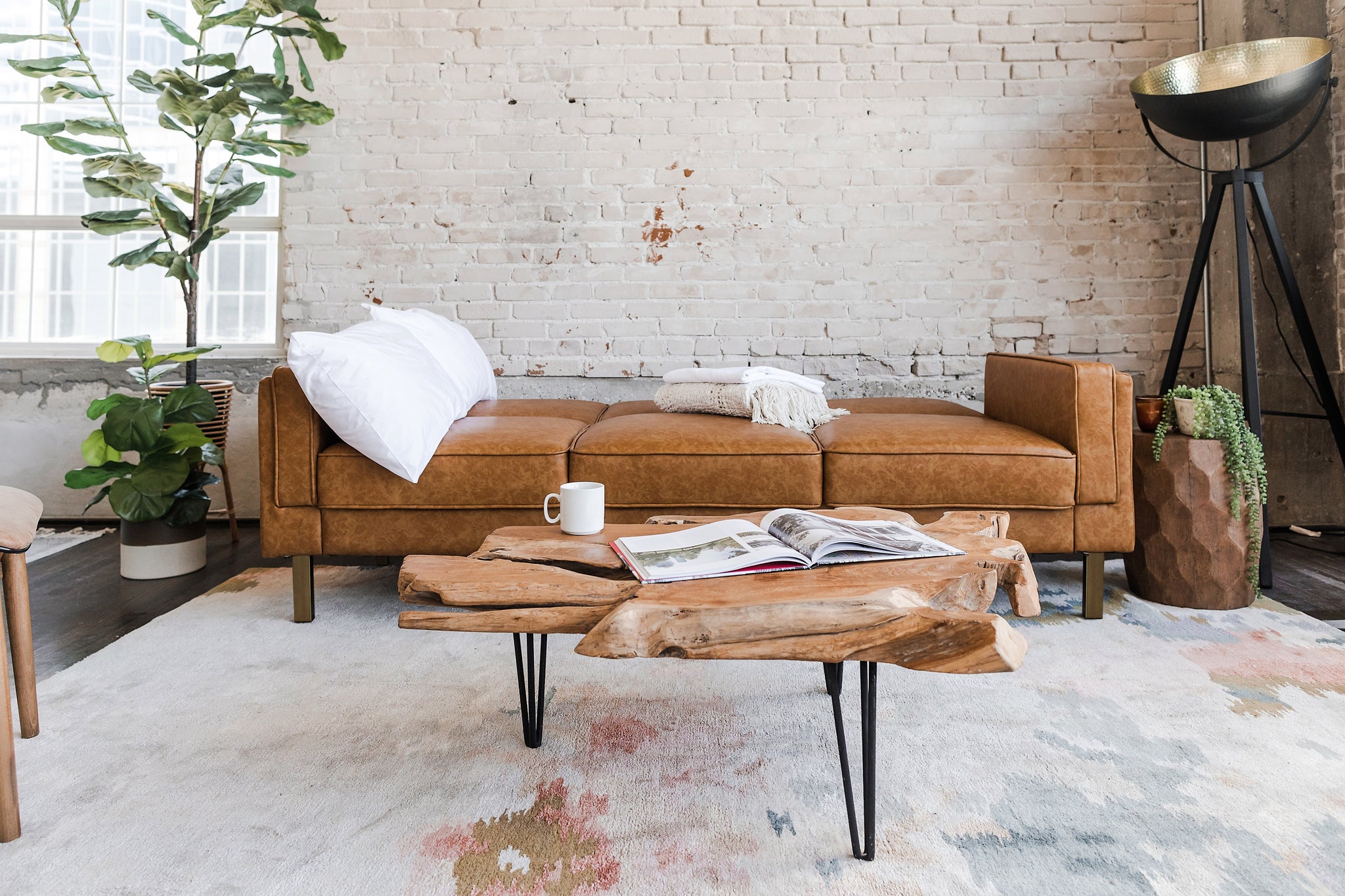 albany sleeper sofa in vegan leather with gold legs in a living room setting