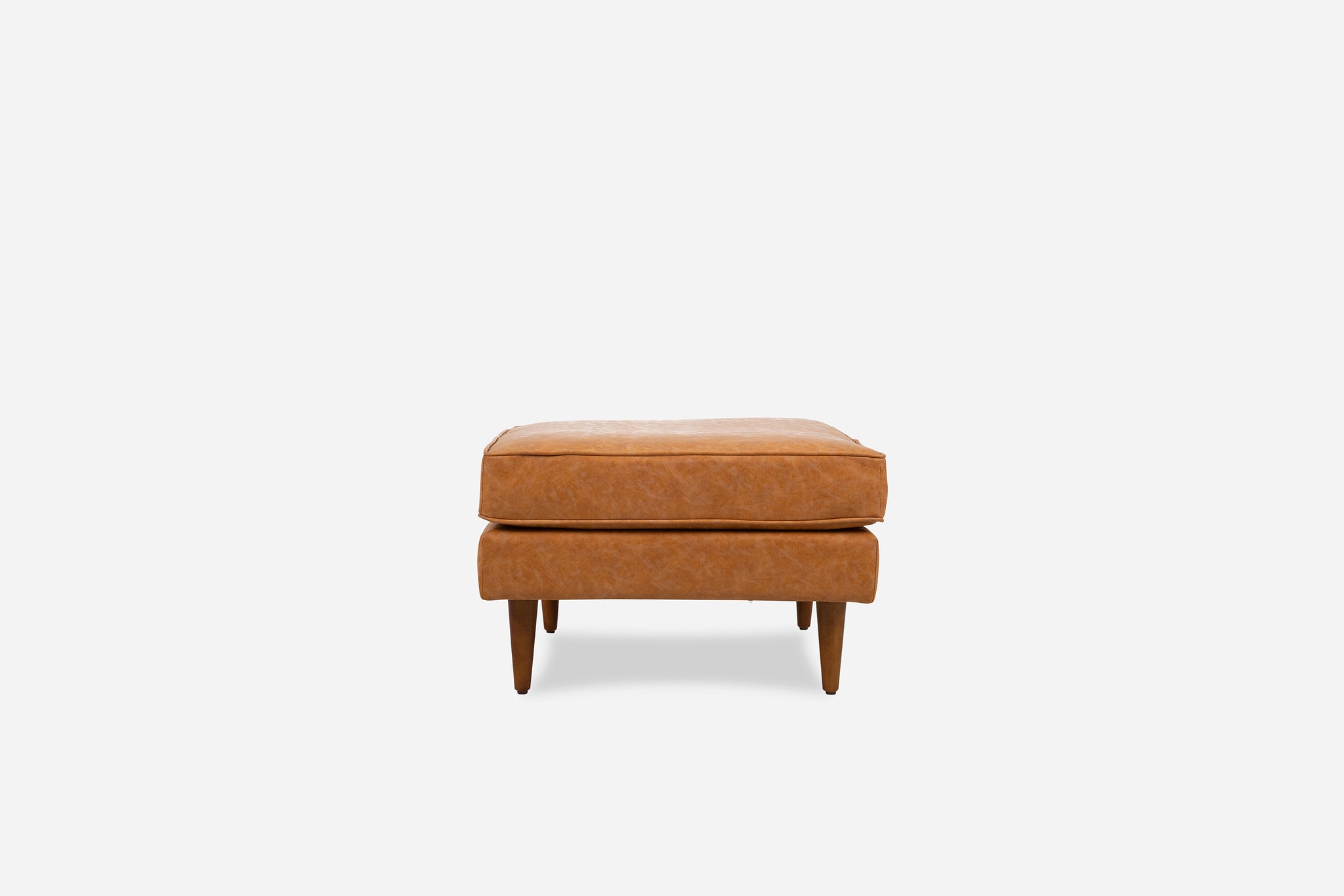 albany ottoman shown in distressed vegan leather with walnut legs